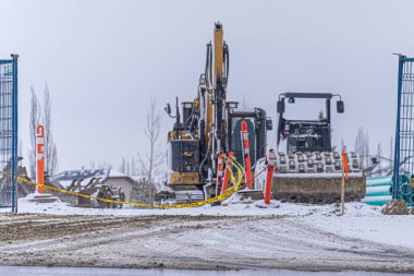 İnşaat ekipmanları tel örgülerin arkasında.