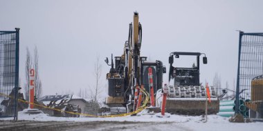 İnşaat ekipmanları tel örgülerin arkasında.