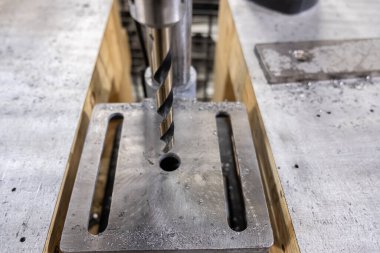 Fabrika zemininde büyük bir matkap ucu makinesi var.