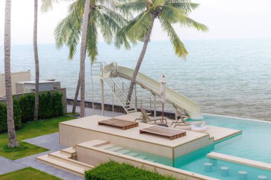Bar tabureleri ve okyanus manzaralı lüks sonsuzluk havuzu, tropikal rahatlama ve yaz tatilleri için mükemmel..