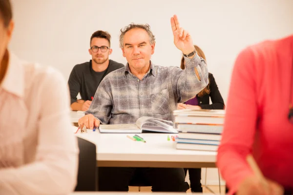 Groupe de personnes d'âge différent assis en classe et assister — Photo