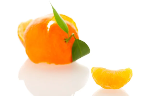 Cáscara espiral de mandarina naranja con hojas verdes y una rebanada de c —  Fotos de Stock