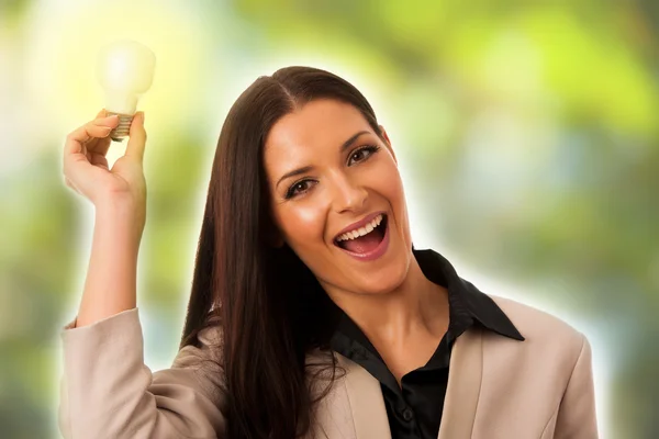 Woman holding light bulb above head as a sign of new idea. Stock Photo