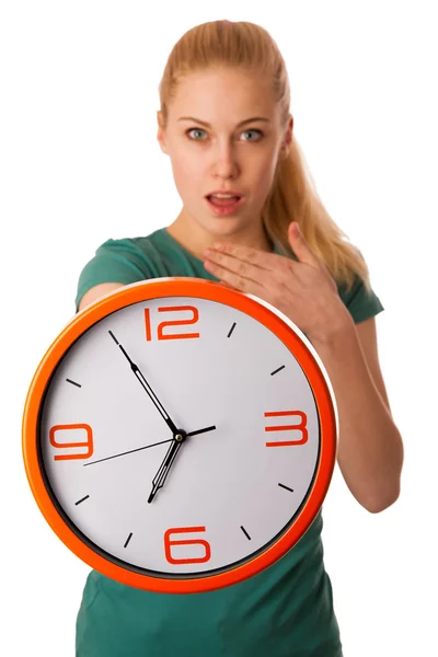 Blonde woman holding big clock in hand isolated over white. — Stock Photo, Image