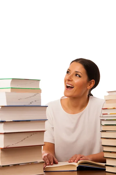 Mulher excitada lendo atrás da mesa entre duas pilhas de livros — Fotografia de Stock