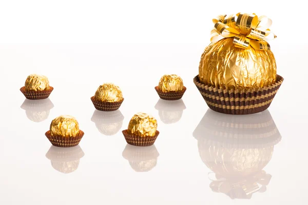 Nagy kerek csokoládé fóliába csomagolva arany nagy íj a — Stock Fotó