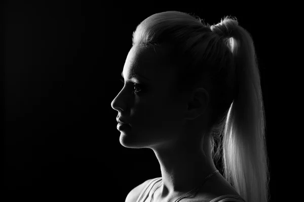 Vrouw staand silhuette in duisternis met zacht licht op gezicht. — Stockfoto