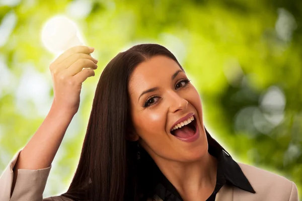 Mulher segurando lâmpada acima da cabeça como um sinal de nova ideia . — Fotografia de Stock