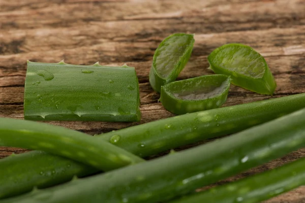 Aloe vera hojas frescas verdes en rodajas decoradas en escritorio de madera . —  Fotos de Stock