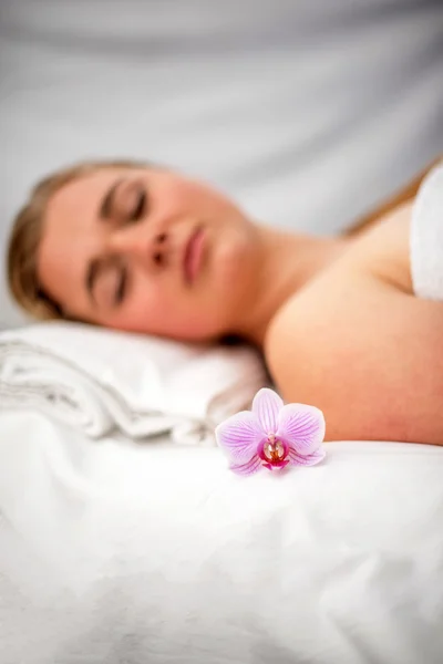 Mulher deitada na mesa de massagem preparada para o tratamento de beleza . — Fotografia de Stock