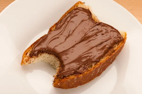 Fatia de pão com chocolate doce nougat spread, mordida . — Fotografia de Stock