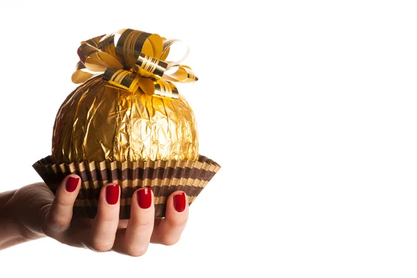 Grand bonbon rond au chocolat enveloppé dans une feuille d'or avec grand arc sur — Photo