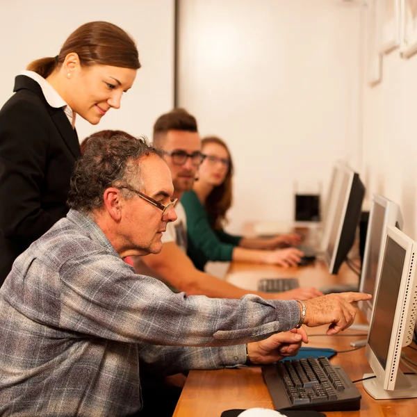 Gruppe von Erwachsenen, die Computerkenntnisse erlernen. Generationenübergreifender Tran — Stockfoto