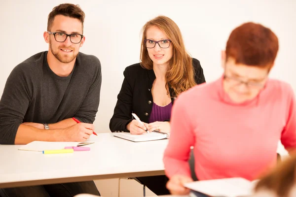 Groupe de personnes d'âge différent assis en classe et assister — Photo