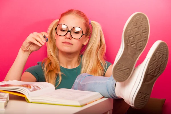 Грайлива школярка з великими окулярами зосереджена в читанні b — стокове фото