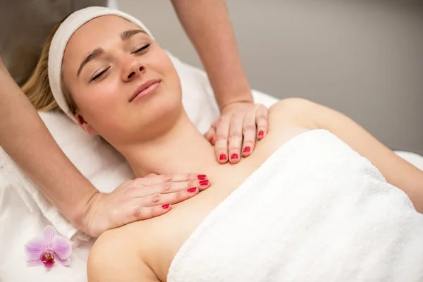 Jovem deitada na mesa de massagem recebendo massagem facial. Beaut... — Fotografia de Stock