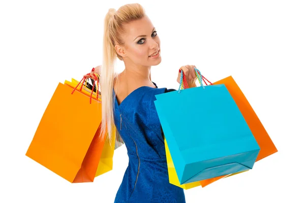 Mulher loira feliz segurando um monte de sacos de compras vibrantes depois — Fotografia de Stock