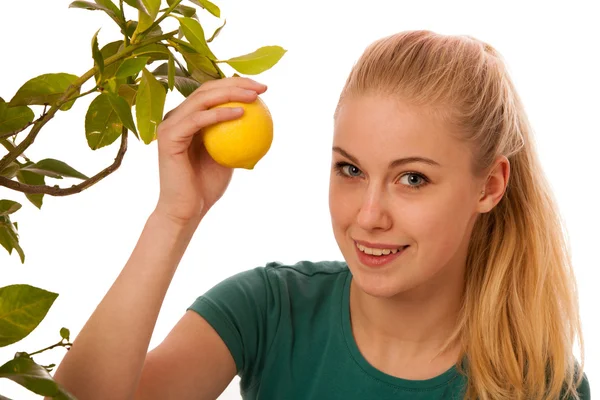 Blond kobieta zbieranie cytryn duży, żółty z ekologicznymi rosną — Zdjęcie stockowe
