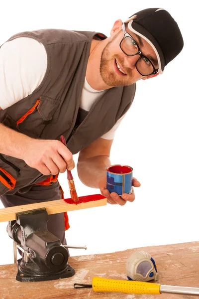 Ein Tischler pinselt Holz in roter Farbe isoliert über weißem Backgr — Stockfoto