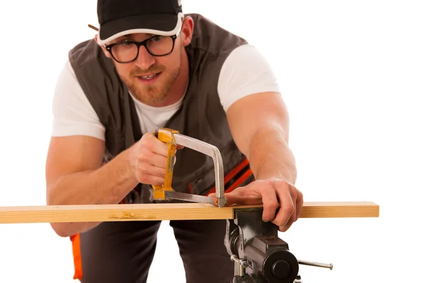 Young carpenter cuts a wooden lath with a saw isolated over whit — Stock Photo, Image