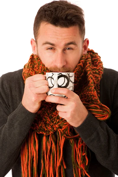 Homem com gripe e febre envolto em cachecol segurando copo de cura t — Fotografia de Stock