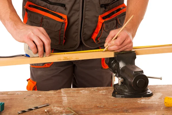 Ein Tischler misst eine Holzplanke in einer Werkstatt, die isoliert über — Stockfoto