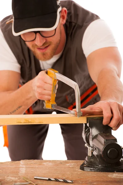 Young carpenter cuts a wooden lath with a saw isolated over whit — Stock Photo, Image