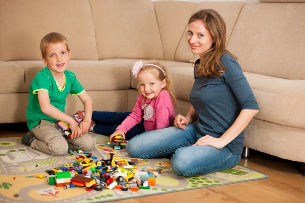 Kinder und ihre Mutter spielen mit Klötzen auf dem Boden — Stockfoto