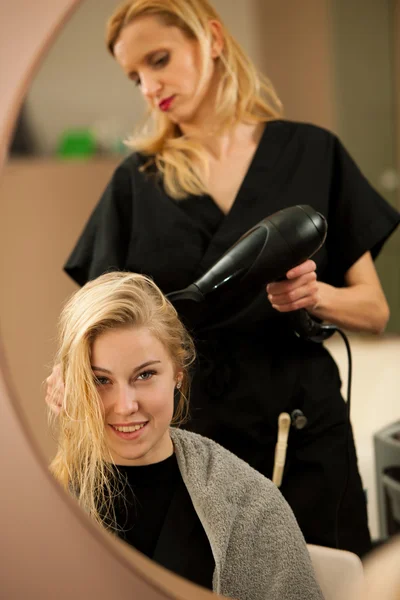 Профессиональный стилист на работе - парикмахер делает прическу — стоковое фото