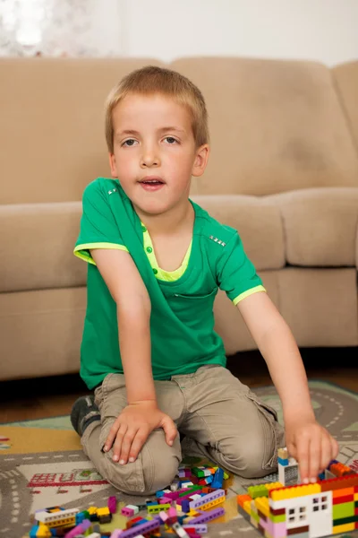 Junge spielt mit Klötzen auf dem Boden im Wohnzimmer — Stockfoto