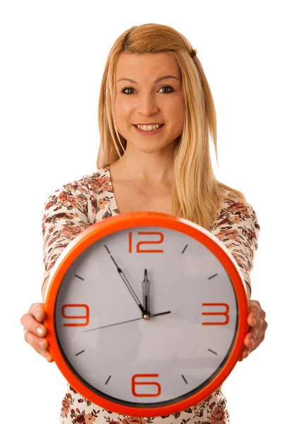 Linda mujer rubia con un gran reloj naranja gesto de llegar tarde es Imagen De Stock