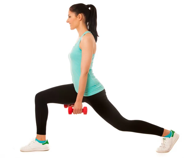 Mulher bonita fazendo exercício lunge com halteres vermelhos em — Fotografia de Stock