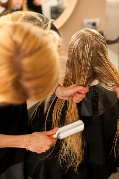 Peluquero en el trabajo - peluquero peinando el cabello al cliente —  Fotos de Stock