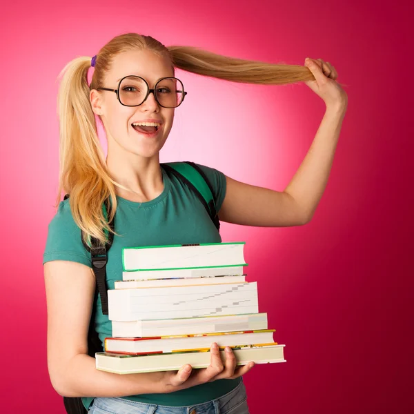 Nieuwsgierig, speels en ondeugend schoolmeisje met stapel boeken en grote — Stockfoto