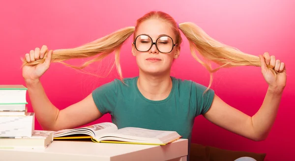 Verspieltes Schulmädchen mit großer Brille am Tisch — Stockfoto