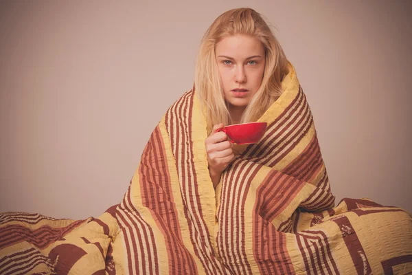 Kranke Frau sitzt auf schlecht in eine Decke gehüllt und fühlt sich krank, hat — Stockfoto