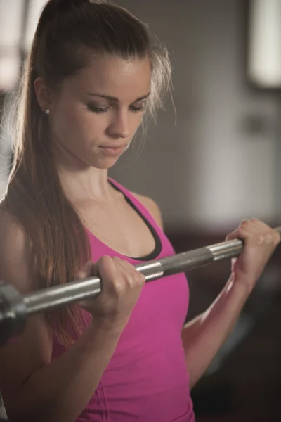 Entrenamiento de mujer en gimnasio con barra de pesas - entrenamiento de levantamiento de pesas —  Fotos de Stock