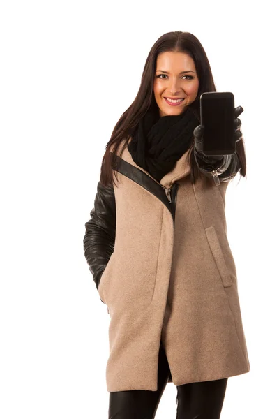 Жінка в зимовому пальто стоїть впевнено, показуючи екран селе — стокове фото