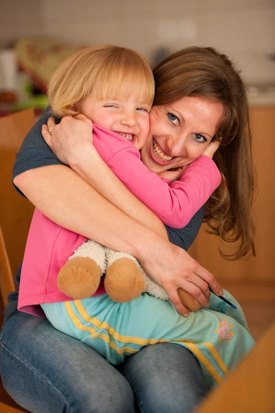 Mutter umarmt ihre süße kleine Tochter — Stockfoto