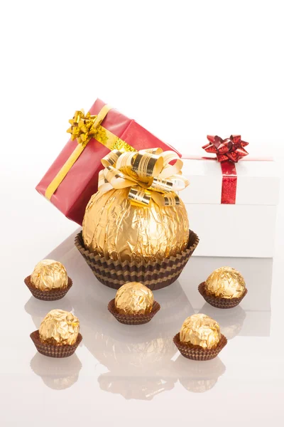 Big round chocolate candy wrapped in golden foil with big bow on