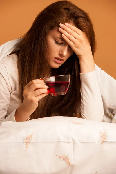 Betegség influenza - beteg nő teát inni az ágyban — Stock Fotó