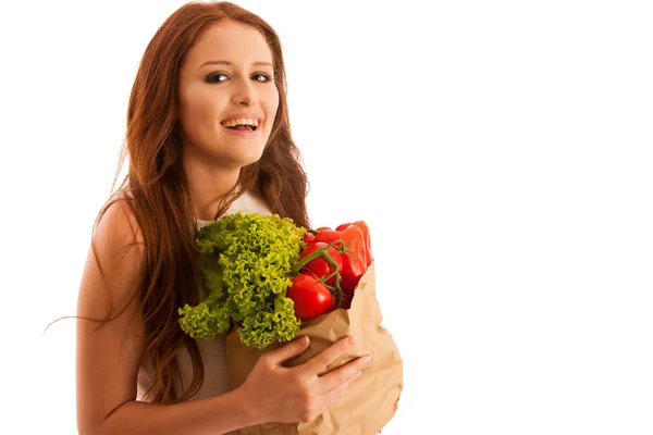 Mujer que lleva una bolsa llena de varias verduras aisladas durante wh — Foto de Stock