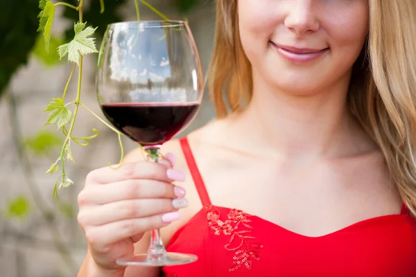 Vacker kvinna dricker rött vin utomhus på en varm sommar afternoo — Stockfoto