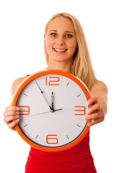 Blonde zakenvrouw in rood shirt houdt klok als teken voor tijd — Stockfoto