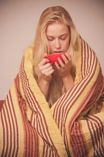 Mujer enferma sentada en mal envuelta en una manta sintiéndose mal, tiene — Foto de Stock
