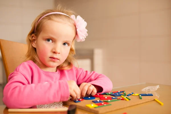 Linda niña pin apuntando bloques en tablero de madera jugando w — Foto de Stock