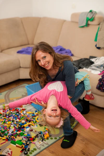 Moeder en jonge dochter spelen in woonkamer — Stockfoto