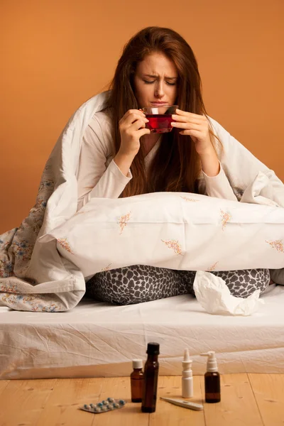 Flu penyakit - wanita sakit minum teh di tempat tidur — Stok Foto