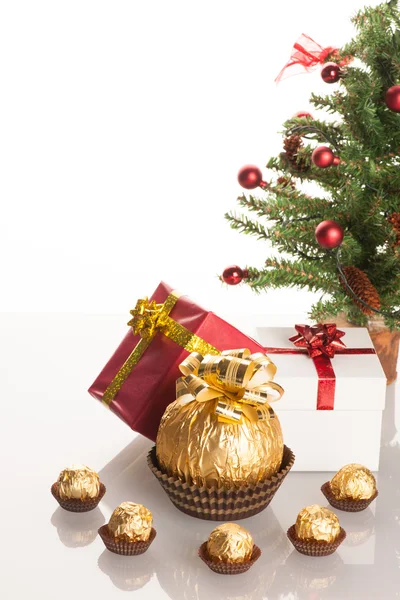 Grand bonbon rond au chocolat enveloppé dans une feuille d'or avec grand arc sur — Photo