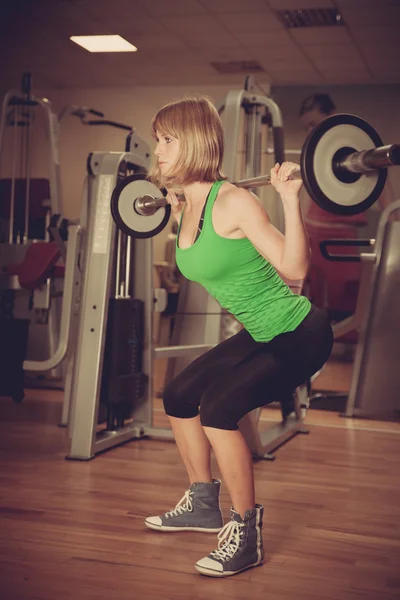 Aantrekkelijke jonge vrouw houdt zich bezig met fitness sportclub werken — Stockfoto